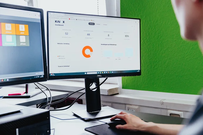 Mitarbeiter arbeitet am PC und hat das KAIOX Dashboard geöffnet
